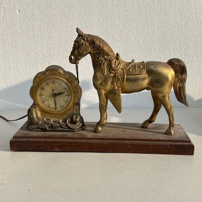 United Shelf Clock | Clock with hors, the face with Arabic numerals and signed "UNITED," surrounded by a metal frame decorated...