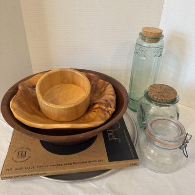 Collection of wooden bowls, pizza stones, and corked jars