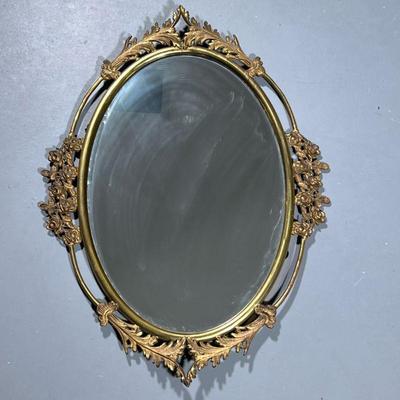 Floral Framed Mirror | Oval mirror in a gilt metal frame with flowers and acanthus leaves. - h. 25 x w. 19 in

