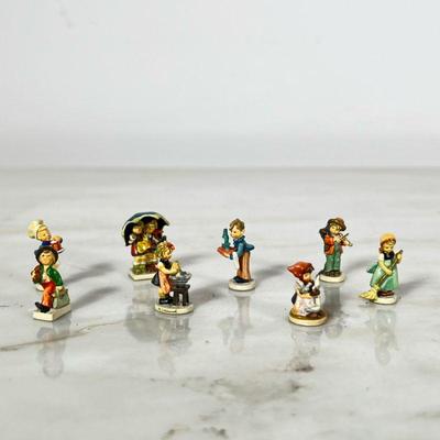 (8pc) Miniature Hummel | Very little Hummel figurines, the set includes but not limited to “Merry Wanderer”, “Little Sweeper”,...