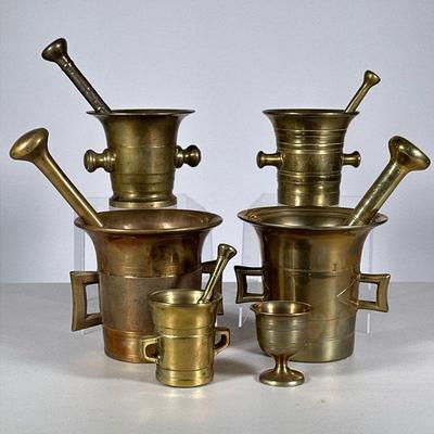 Group Brass Mortar & Pestles | Five mortar and pestle sets, plus a small brass cup.