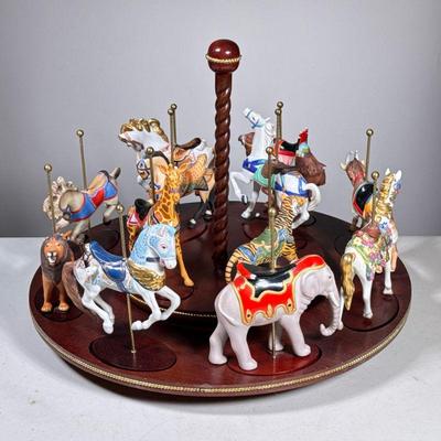 Franklin Mint Carousel | Needlepoint in earthy tones showing a lady lounging surrounded with cupids/angels, in a wooden frame; 30 x 19.5...