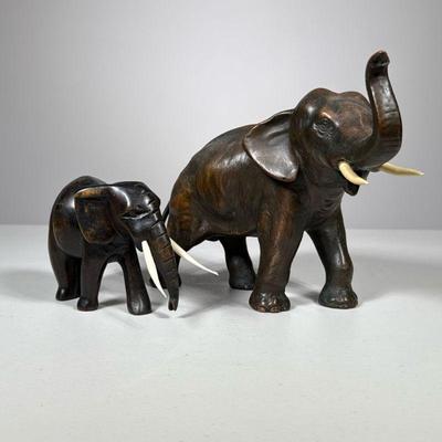 (2pc) Elephants With Tusks | Including a bronze elephant figure and a smaller carved wood elephant. - h. 7 x w. 4 x l. 9.5 in (largest,...
