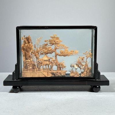 MINIATURE CARVED WOOD SCENE | Asian miniature carved wood scene in black lacquered display box, showing a pagoda with trees and cranes....