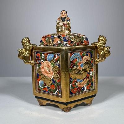 Japanese Porcelain Censer | Elaborately decorated gilt porcelain box with lion-form handles, the lid with a male figure finial; with red...