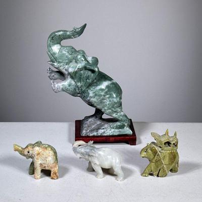 (4pc) Chinese Carved Elephants | Elephant figurines in carved soapstone, serpentine, and other stone materials. - h. 9.5 x l. 7 in...
