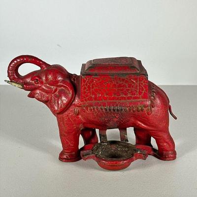 Cast Iron Cigarette Dispenser | Red cast iron elephant-form cigarette box and holder with turning dispense mechanism, with ashtray. - h....