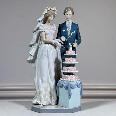 Lladro Bride & Groom | Porcelain Lladro figure showing a couple cutting wedding cake. Marked on bottom. - h. 13 x w. 7 x d. 8 in

