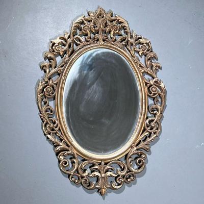 Gold Painted Mirror | Composite ornate framed oval mirror with decorative scrollwork. - h. 34 x w. 22 in
