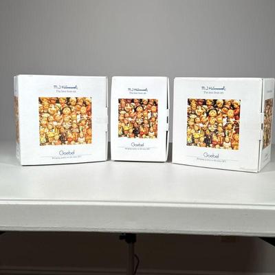 (3pc) Hummels in Boxes | Three Hummel figurines including “Art Critic”, “Accordian Boy” and “Bahamas News", each marked on the...