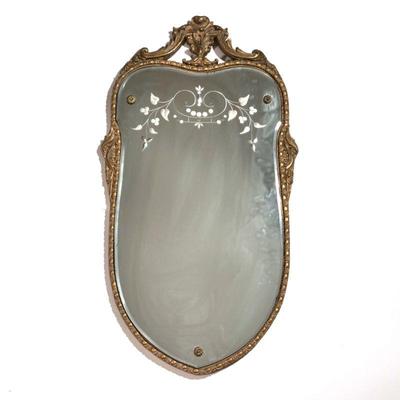 Mirror with Gold Gilt Frame | Italian style gilt wall mirror of crest-shape, with leaf grapevine etching on top of mirror. - h. 31 x w....