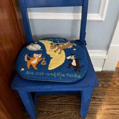 adorable child's chair with a needlepoint cushion