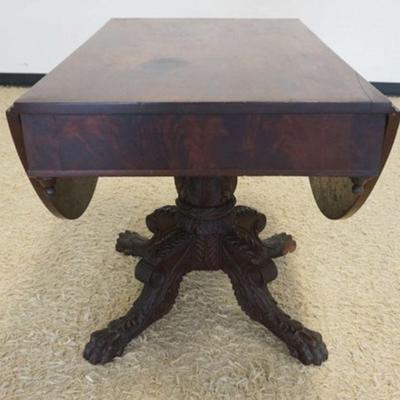 Sale Photo Thumbnail #155: 1156	EMPIRE MAHOGANY DROP LEAF TABLE ON HEAVILY CARVED CLAW FOOT AND PEDESTAL BASE, APPROXIMATELY 39  IN X 25 IN X 29 IN H, EACH LEAF APPROXIMATELY 15 1/2 IN, LOSS TO CARVING ON ONE PAW
