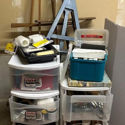 Two Shelving Units With Paint And Art Supplies And Three Easles