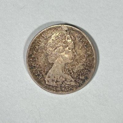 1965 CANADIAN SILVER DOLLAR COIN | 1965 Canadian Silver Dollar coin with 2 men in canoe on face and Queen Elizabeth II on verso; 0.7 ozt...