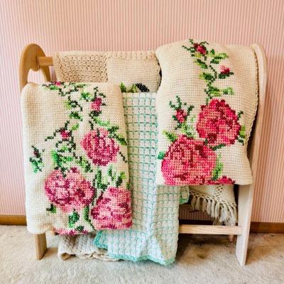 Light Wood Quilt Rack w/ Floral Motif Crochet Blankets, & More	