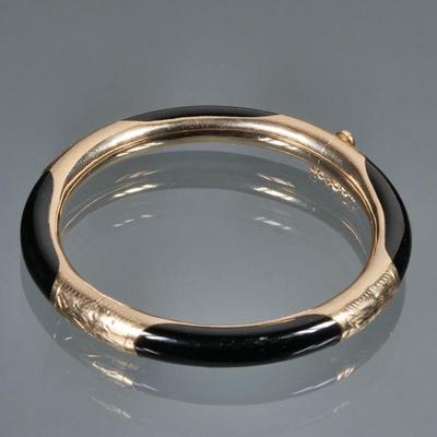 14K GOLD & ONYX HARD BRACELET | Designed as a 14K gold and carved onyx bangle bracelet, marked "585 14K" on clasp; Total...