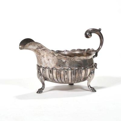 "18TH CENTURY ENGLISH STERLING SAUCE BOAT | c. 1779 sterling silver sauce or gravy boat having a gadrooned body on four hoof feet,...