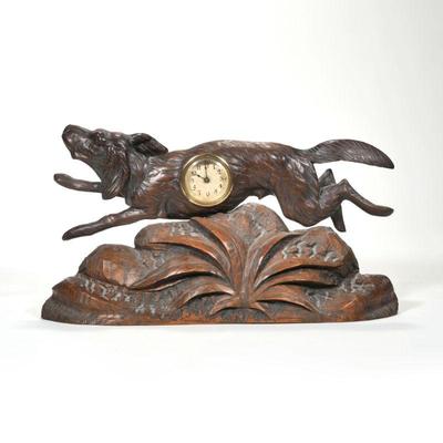 "BLACK FOREST CARVED HUNTING DOG-FORM CLOCK | Depicting a dog leaping over a carved plant, his body inset with a clock having a...