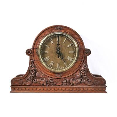 "ORNATELY CARVED MANTEL CLOCK | Finely carved with grapevines, scrolls, and flowers, the body with scale carving around the arched...