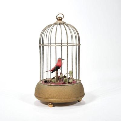 "GERMAN MUSICAL BIRD AUTOMATON | Designed as a red and black feathered bird within a brass cage on three ball feet, marked...