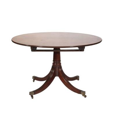 "REGENCY STYLE PEDESTAL BREAKFAST TABLE | Round top table with inlaid wood border, over four reeded legs terminating in brass capped...