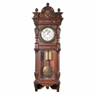 REGULATOR WALL CLOCK | White enameled face with Arabic numeral markers in a carved walnut case with fancy hammered brass mounts of...