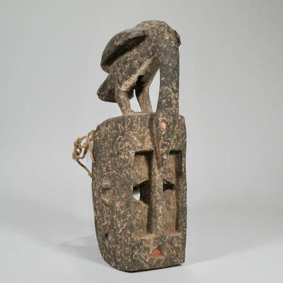 "CARVED AFRICAN MASK | Carved wood & painted African mask crested by a bird with rope net backing
h. 19 x w. 5.5 x d. 9 in."