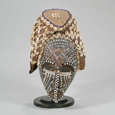 "AFRICAN COWRY SHELL MASK | Wood carved & painted mask with beadwork accents, canvas head covering with shell design, on stand...