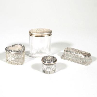 "(4pc) STERLING LIDDED VANITY BOXES | Including an English sterling silver lidded cut glass box, the lid decorated with angels en...
