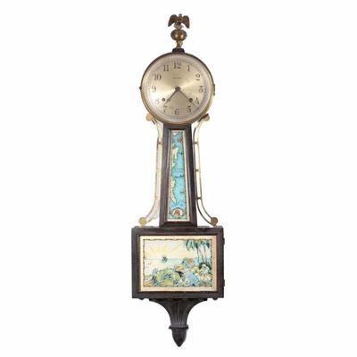 "INGRAHAM TREASURE ISLAND BANJO CLOCK | In a walnut case, silvered dial with Arabic numerals, with reverse painted glass panels,...