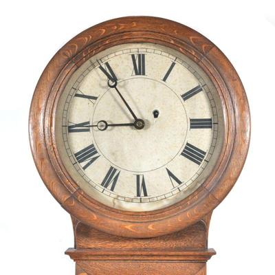 "OAK CASED REGULATOR CLOCK | Old paper face with Roman numeral markers
h. 34 x w. 16 x d. 5.5 in."