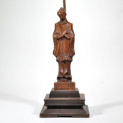 "YASHA HEIFETZ CARVED FIGURAL TABLE LAMP | A carved wood female figure in robe with fan on a tiered wood base, with brass hardware;...