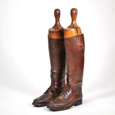 "LEATHER RIDING BOOTS & FORMS | A pair of women's brown leather lace up riding boots and wooden boot forms
h. 23 x l. 11...