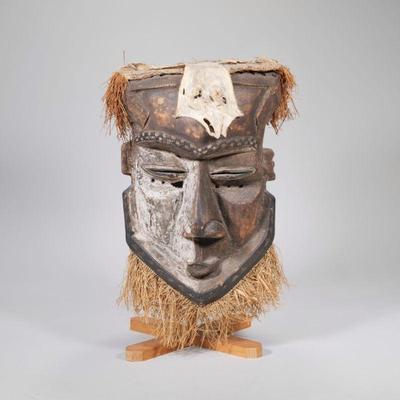 "LARGE AFRICAN MASK | Carved wood African mask painted half white with straw hair and animal hide on top
h. 19.25 x w. 10 x d. 10...