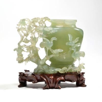 "RETICULATED CARVED JADE VESSEL | On a conforming carved wood stand
h. 5.5 x w. 3 x l. 7 in. (Jade only)"
