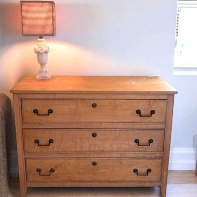 Wood three drawer dresser with small lamp