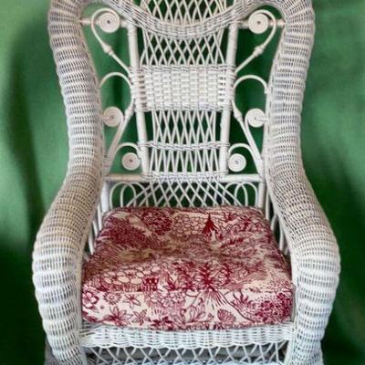 White wicker spring rocker with pin wheel back arched shoulders