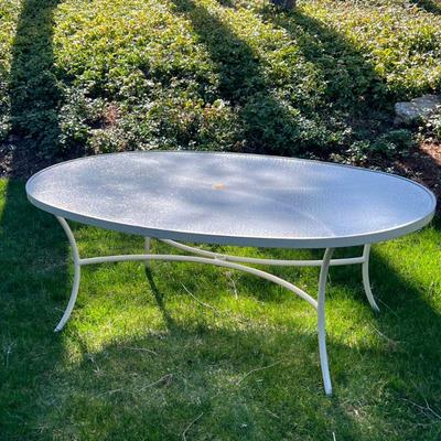 Outdoor Patio Table | Oval top patio table with umbrella, table by Tropitone. - h. 26.5 x w. 47.5 x l. 69 in (approx.)

