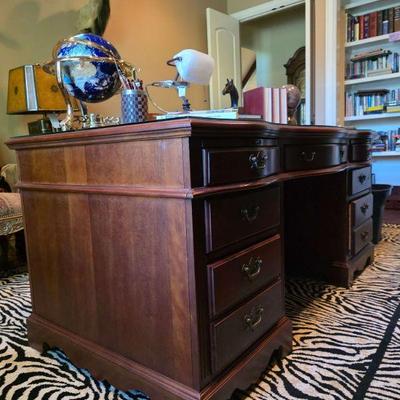 Executive desk and large animal print rug. 