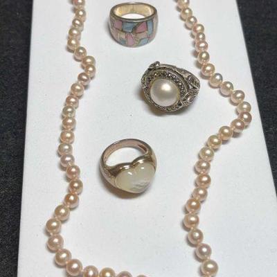 Pink pearl strand complementing rings