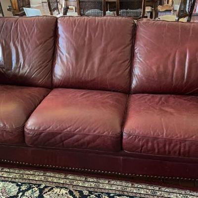 Burgundy Red leather sofa with arching arms and brass nailhead accents