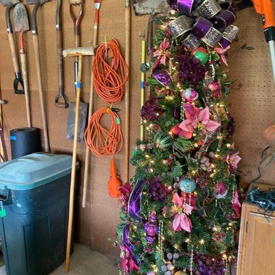 fully decorated christmas tree and yard tools