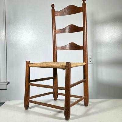 SPINDLE CARVED RUSH LADDER BACK CHAIR | Spindle wood carved ladder back chair with curved back and rush seat. Dimensions: h. 37 x w. 17 x...
