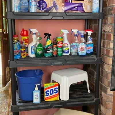 Black plastic shelf unit with cleaning supplies