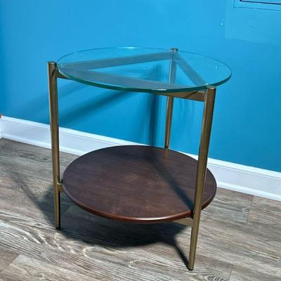Art Deco Style Side Table | Round glass top over a brass triangular frame with a wood medial shelf Dimensions: h. 22.25 x dia. 20.25 in.

