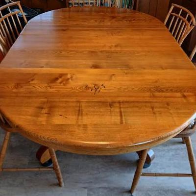 Beautifully hand-crafted solid oak dining table, from the 1920’s. Goes from a circle to rectangle with the 3 leaves in. 29.5"h x...