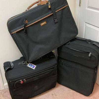 Three-piece black luggage set with brown and black trim