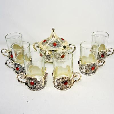his stunning auction lot includes a silver-handled drinkware set featuring six glasses, a beautifully crafted sugar pot, and a decorative...