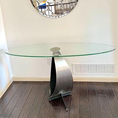 Modern console table featuring a beveled oval glass top with a sculptural metal base.
5 ft long, 18” deep, 29” Tall